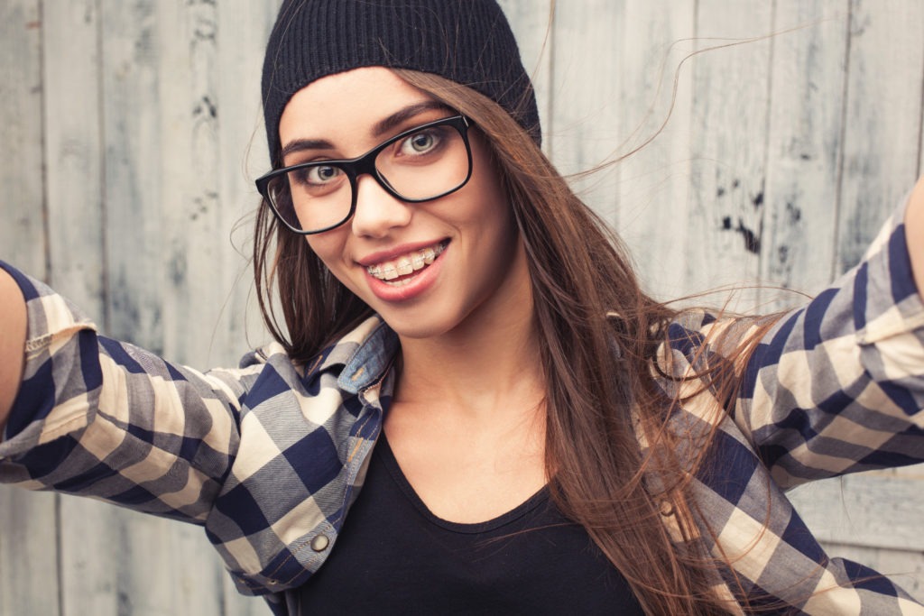 Hip teen girl with braces and glasses