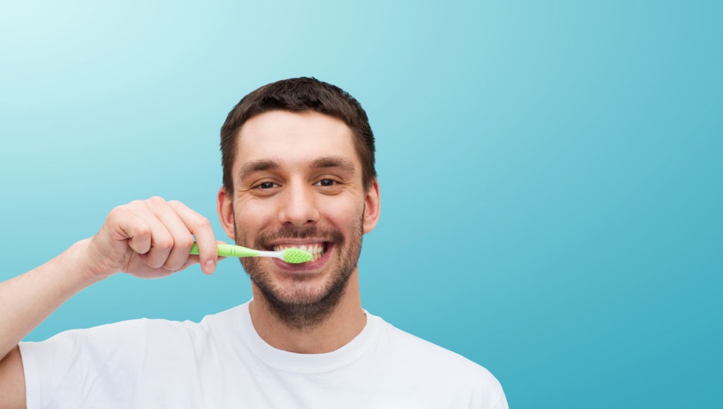 smiling young man with toothbrush