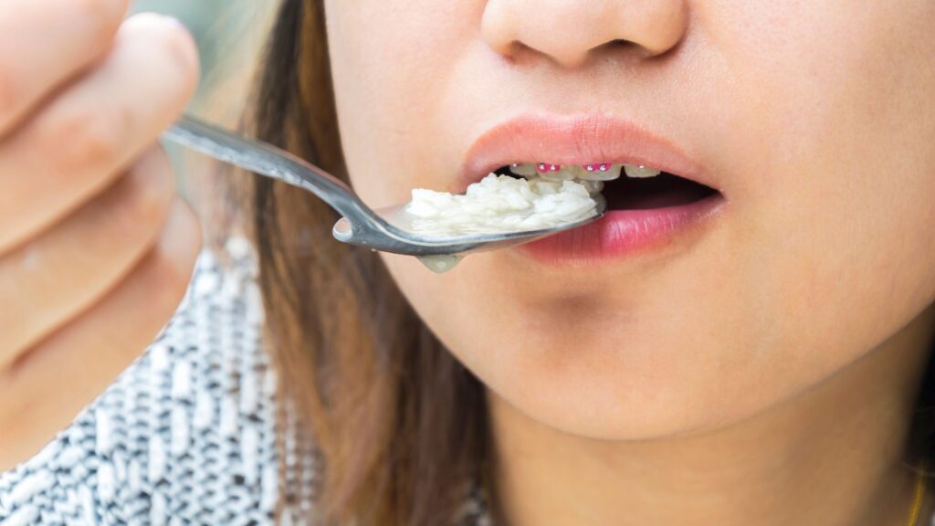 girl eating rice with braces