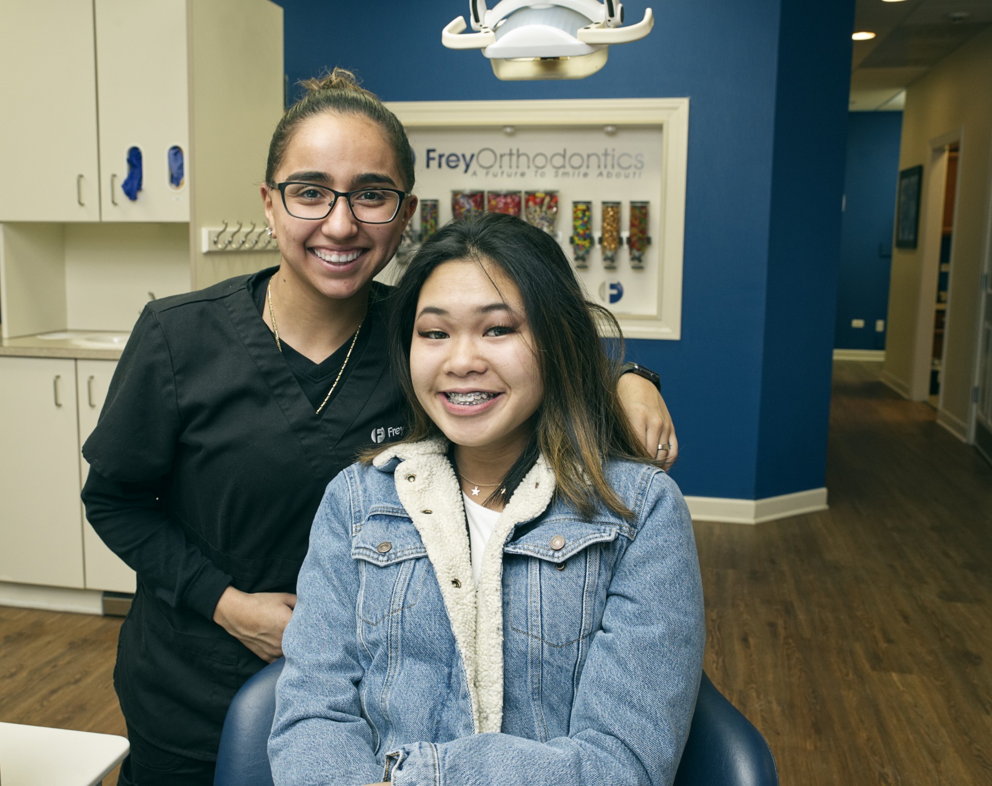 Smiling patient with braces and orthodontist in Frey Orthodontics office, showcasing modern braces treatment in Naperville.