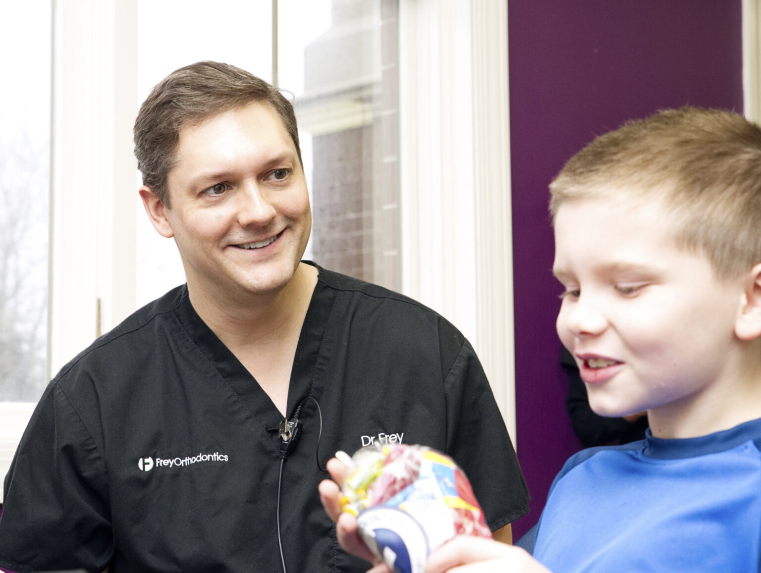Dr. Frey interacting with a young patient in a modern orthodontic office, showcasing a friendly atmosphere and personalized care.